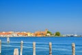 Panoramic view of Lusenzo lagoon with wooden poles in water and Chioggia town