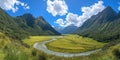 A panoramic view of a lush valley with a winding river surrounded by mountains and blue skies Royalty Free Stock Photo