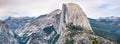 Panoramic view of the majestic Half Dome and the surrounding wilderness area with mountain peaks and ridges still covered by snow Royalty Free Stock Photo