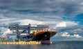 Merchant Cargo Container vessel berthed with cloudy backdrop