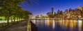 Midtown Manhattan skyscrapers and the East River at twilight from Roosevelt Island promenade in Summer. New York City