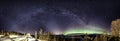 Panoramic view of Milky Way which starts in the middle of brilliant green Aurora . It is curved above horizon line and shining