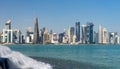 Panoramic view of modern skyline of Doha with small waterfall foreground. Qatar on sunny day