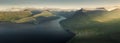 Panoramic view of mountain landscape at Hvithamar on the Faroe Islands with fjord and sun rays from side