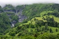 Panoramic view on mountain waterfalls, green forests and apline meadows near Saint-Gervais-les-Bains, Savoy. France