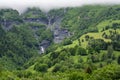 Panoramic view on mountain waterfalls, green forests and apline meadows near Saint-Gervais-les-Bains, Savoy. France