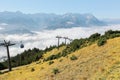 The panoramic view of Mountain Zugspitze from top of Mount Wank with a cable car gliding above sea of clouds in Garmisch Royalty Free Stock Photo