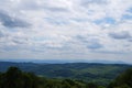 Panoramic view of mountains covered with green grass and coniferous forest under blue sky Royalty Free Stock Photo