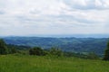 Panoramic view of mountains covered with green grass and coniferous forest under blue sky Royalty Free Stock Photo