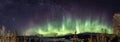 Panoramic view of multicolored Aurora curved above Scandinavian mountains and frozen lake, very cold winter night, deep clear sky Royalty Free Stock Photo