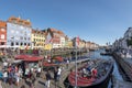 Panoramic view at Nyhavn Canal in Copenhagen city. Colourful facades, old ships, touristic boats and crowd of tourists make