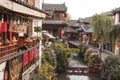 Panoramic view of one of the canals in Lijiang Old Town at sunset with some tourists passing by