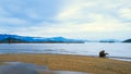 Panoramic view over beach with view on ocean with mountians in the background with a tree trunk washed up by the sea Royalty Free Stock Photo