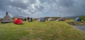 Panoramic view over city camping site in Torshavn, Faroe Islands, at the oceanic shore with many tents and vacationers arriving