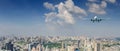 Panoramic view over the evening city, and white passenger plane flying in the day blue sky above a city Royalty Free Stock Photo