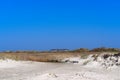 Panoramic view over the grass covered sand at building complex in the distance Royalty Free Stock Photo