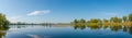Panoramic view over a lake near Elbe river with wind turbines at sunny day and blue sky, Magdeburg, Germany Royalty Free Stock Photo
