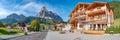 Panoramic view over magical Dolomite peaks, forests and hotels at sunny day and blue sky, Colfosco, Corvara, at Puez-Geisler, Puez