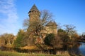 Panoramic view over moat on medieval water castle and defensive tower with bare trees in winter against blue sky - Krefeld Linn Royalty Free Stock Photo