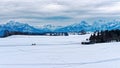 Panoramic view over snowy pre-alpine landscape with two riders on horses