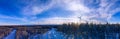 Panoramic view over windmills farm rising above winter pine tree forest in Northern Sweden. Bright Sun on blue sky, frosty winter Royalty Free Stock Photo