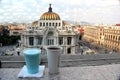 panoramic view of the palace of fine arts in mexico city with bird, coffee and blue drink in the foreground Royalty Free Stock Photo