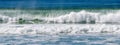 Panoramic view of a peaceful beach, with rolling waves of the ocean lapping against the shore