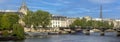 Panoramic view of the Pont des Arts in Paris with the Eiffel Tower under a blue sky and over a beautiful Seine river that divides Royalty Free Stock Photo