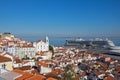 Panoramic view on red roofs on Lisbon centre and big cruise liner ship on Tagus River