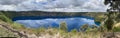 Panoramic view with reflection from water of Blue Lake at Mount Gambier in the Limestone Coast region of South Australia. Royalty Free Stock Photo