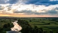 Panoramic view of river between fields during sundown