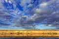 Panoramic view of riverbank with reflections of white fluffy clo