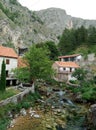 Rocks, houses and Duman, the spring of the Bistrica River in the small town of Livno in Bosnia and Herzegovina Royalty Free Stock Photo