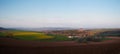 Panoramic view of rolling english countryside with blue sky and green fields and brown muddy ploughed fields Royalty Free Stock Photo