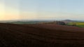 Panoramic view of rolling english countryside with blue sky and green fields and brown muddy ploughed fields Royalty Free Stock Photo