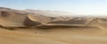 Panoramic view of sand-dunes in the Sossusvlei Nature Reserve in Namibia. These reddish dunes at the main `vlei` salt pan are m