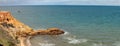 view of a sandstone cliff face with a stone wave breaker poking out into the bay around Melbourne, Victoria, Australia Royalty Free Stock Photo