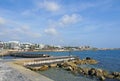 A panoramic view of the seafront in paphos cyprus with hotels and beachfront cafes in the distance behind the beach