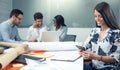 Panoramic view of smiling business woman using phone near office desk with colleagues in the background Royalty Free Stock Photo