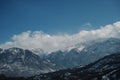 Panoramic view of snow-capped mountains against a blue cloudy sky. Royalty Free Stock Photo