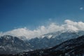 Panoramic view of snow-capped mountains against a blue cloudy sky. Royalty Free Stock Photo