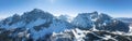 Panoramic view of snow covered mountain range against blue sky on sunny day Royalty Free Stock Photo