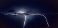 Two bright lightning bolts strike in the vicinity of Gouda, Holland from a violent thunderstorm over the dutch countryside Royalty Free Stock Photo