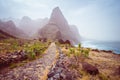 Panoramic view of stony hiking path to Ponta do Sol over amazing arid Aranhas valley with huge mountain peak and house