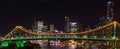 Panoramic view of Story bridge in yellow and green light at night time in Brisbane, Australia