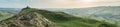 Panoramic view of the summit of Thorpe Cloud with hikers enjoying scenery, Peak District, Derbyshire