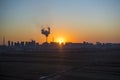 Panoramic view of sunset in the city with silhouette of buildings and industrial factory,pollution city or town concept