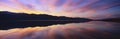 Panoramic view at sunset of flooded salt flats and Panamint Range Mountains in Death Valley National Park, California