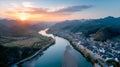 The panoramic view of a sunset over a Chinese town with a river, bridge, and mountains is breathtaking Royalty Free Stock Photo