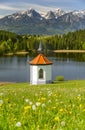 Panoramic view to alps mountain range and lake with romatic chapel in Bavaria